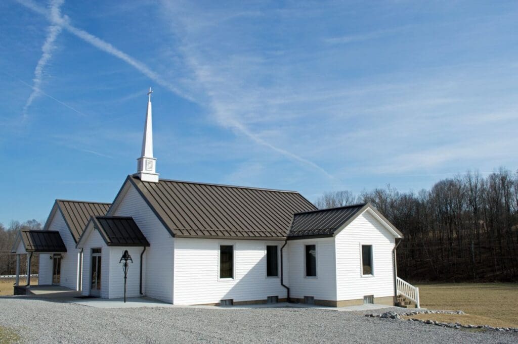 metallic church roof blue sky white house in the middle of nowhere