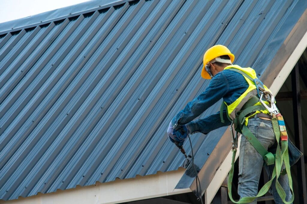 abc step safety award worker installing new corrugated metallic roof