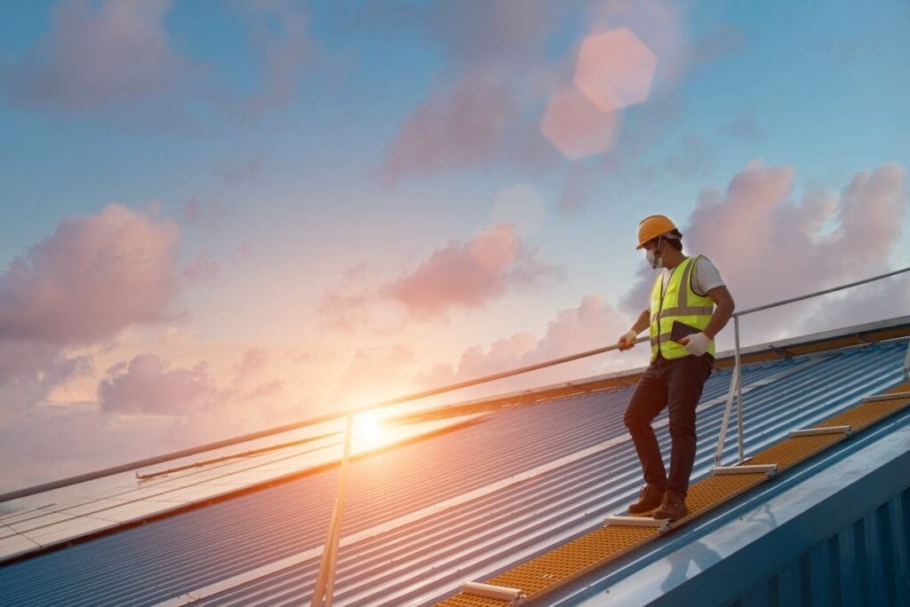 commercial roof financing worker standing on metallic roof