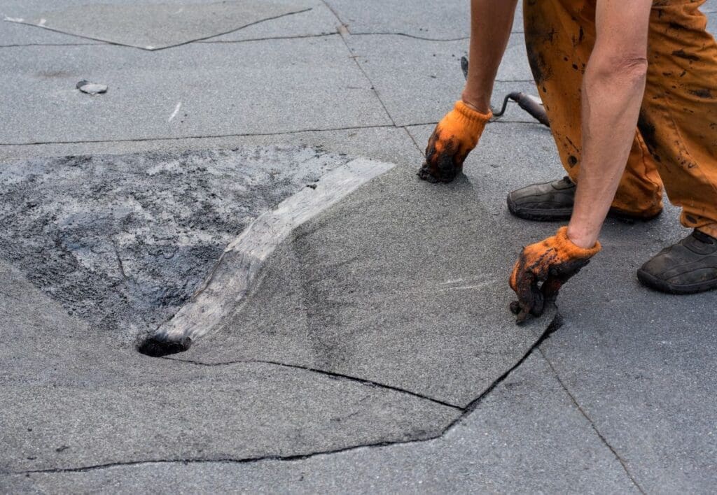 roof scupper worker repairing drainage asphalt roof
