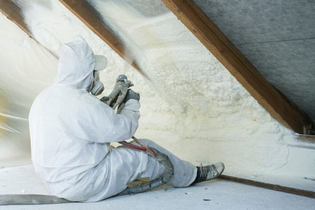 spray foam roof insulation worker applying on slope roof