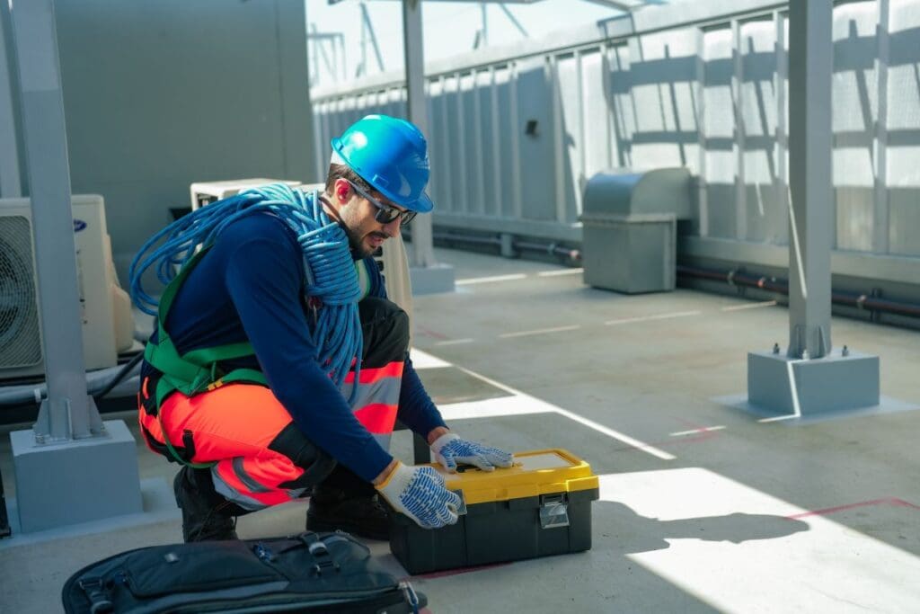commercial roof preventative maintenance worker with rope and toolbox