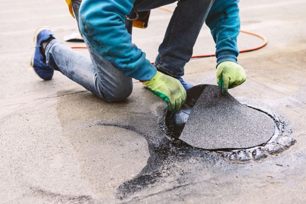 how to repair flat roof felt worker patching asphalt roof