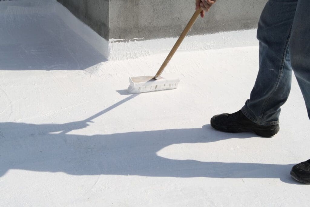 commercial roof preventative maintenance worker applying white coating