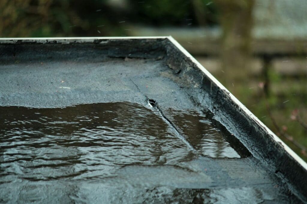 asphalt flat roof repair hole on top of roof water pond