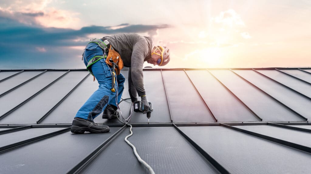 guy working on top standing seam roof panels